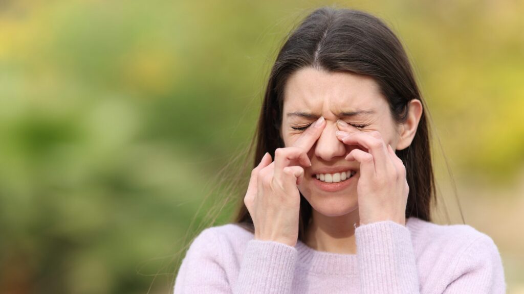 Paziente affetta da sindrome dell'occhio secco che si strofina gli occhi con l'esposizione al vento